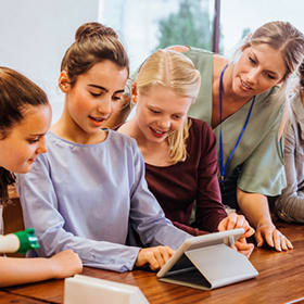 Happy students interacting with a digital device