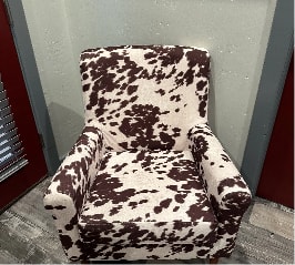 A chair covered in cow print fabric