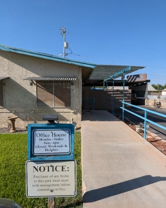 The entrance to the park office with a wheelchair ramp and a sign showing the hours.