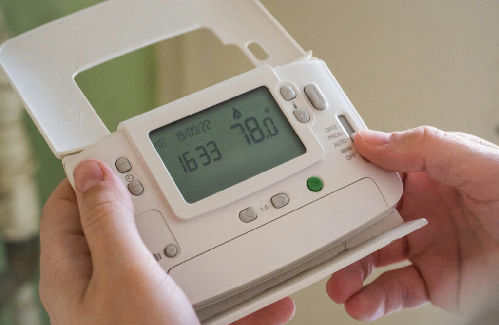 A programmable digital thermostat, illustrating its role in optimizing home comfort for fall and winter seasons.