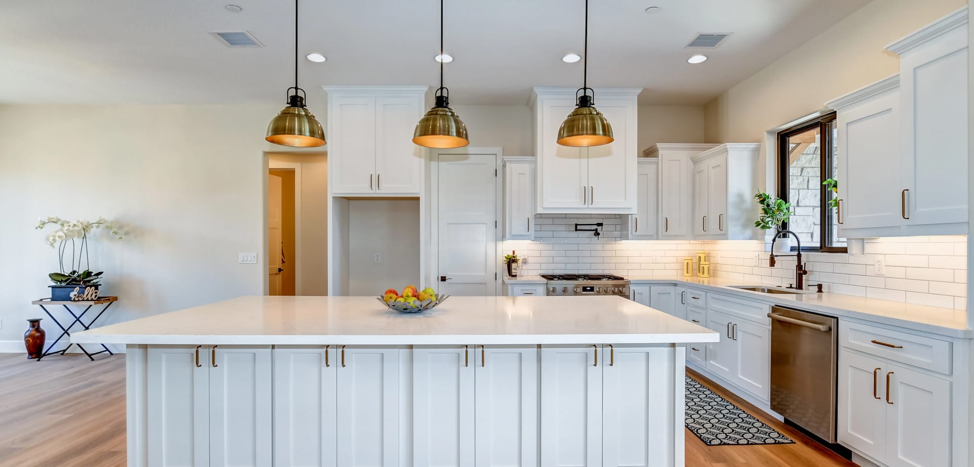 A beautiful kitchen with white cabinets and countertops as well as high end fixtures and appliances