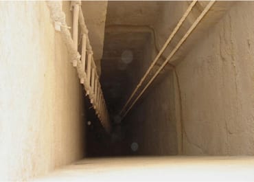 A view down a large pit inside of an egyptian pyramid