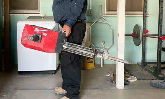 Side view of a plumber holding a plumbing tool