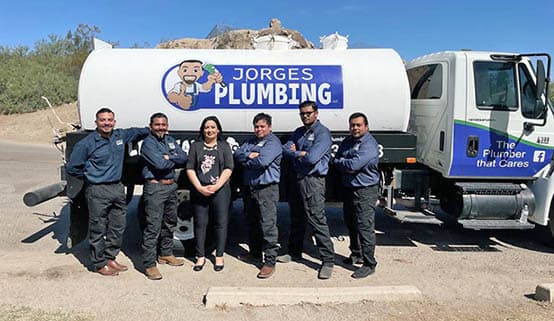 The staff of Jorge's Plumbing standing in front of a septic truck