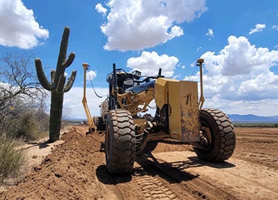 A heavy equipment in a beautiful desert scene with clouds