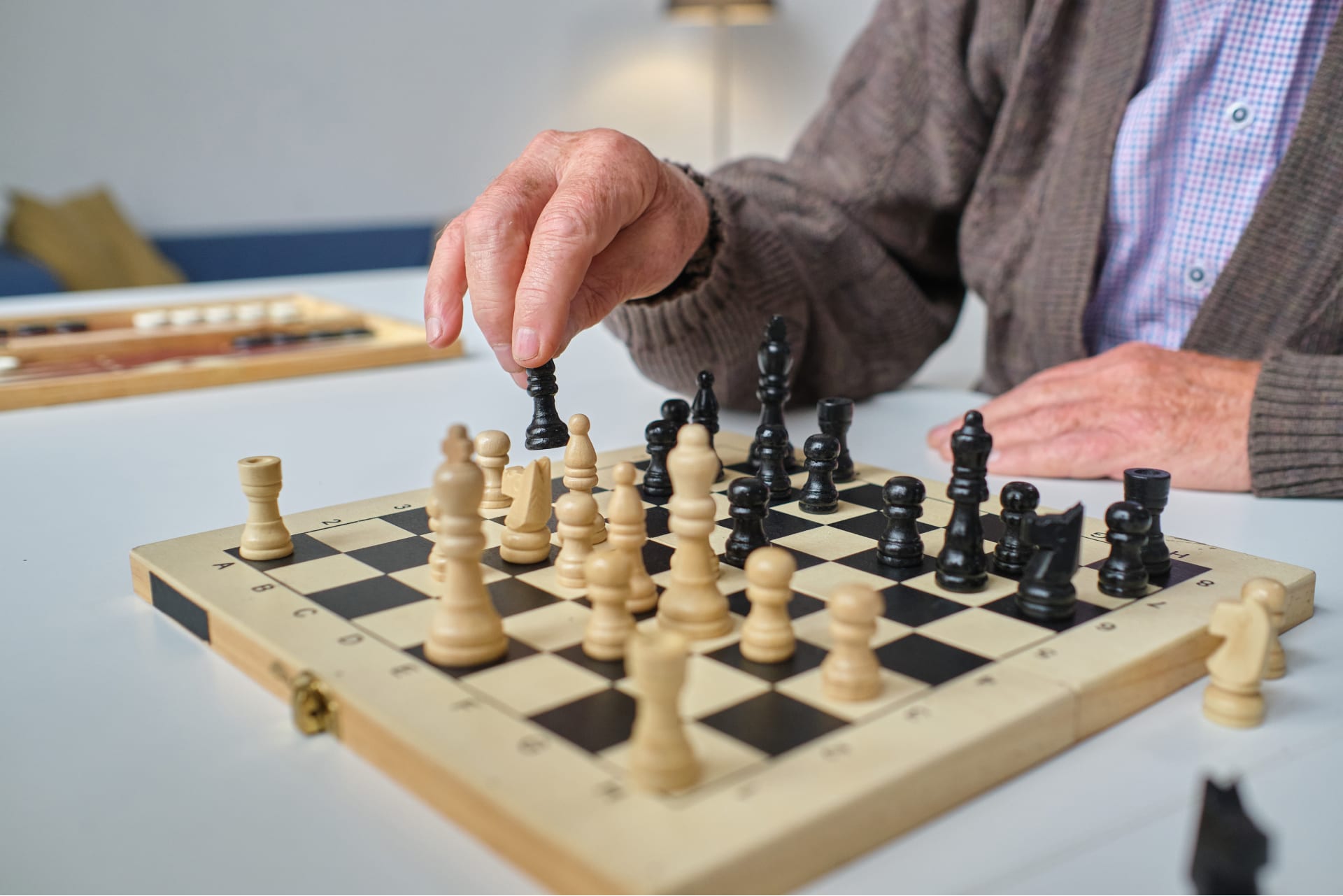 Senior citizen man playing chess at an assisted living home