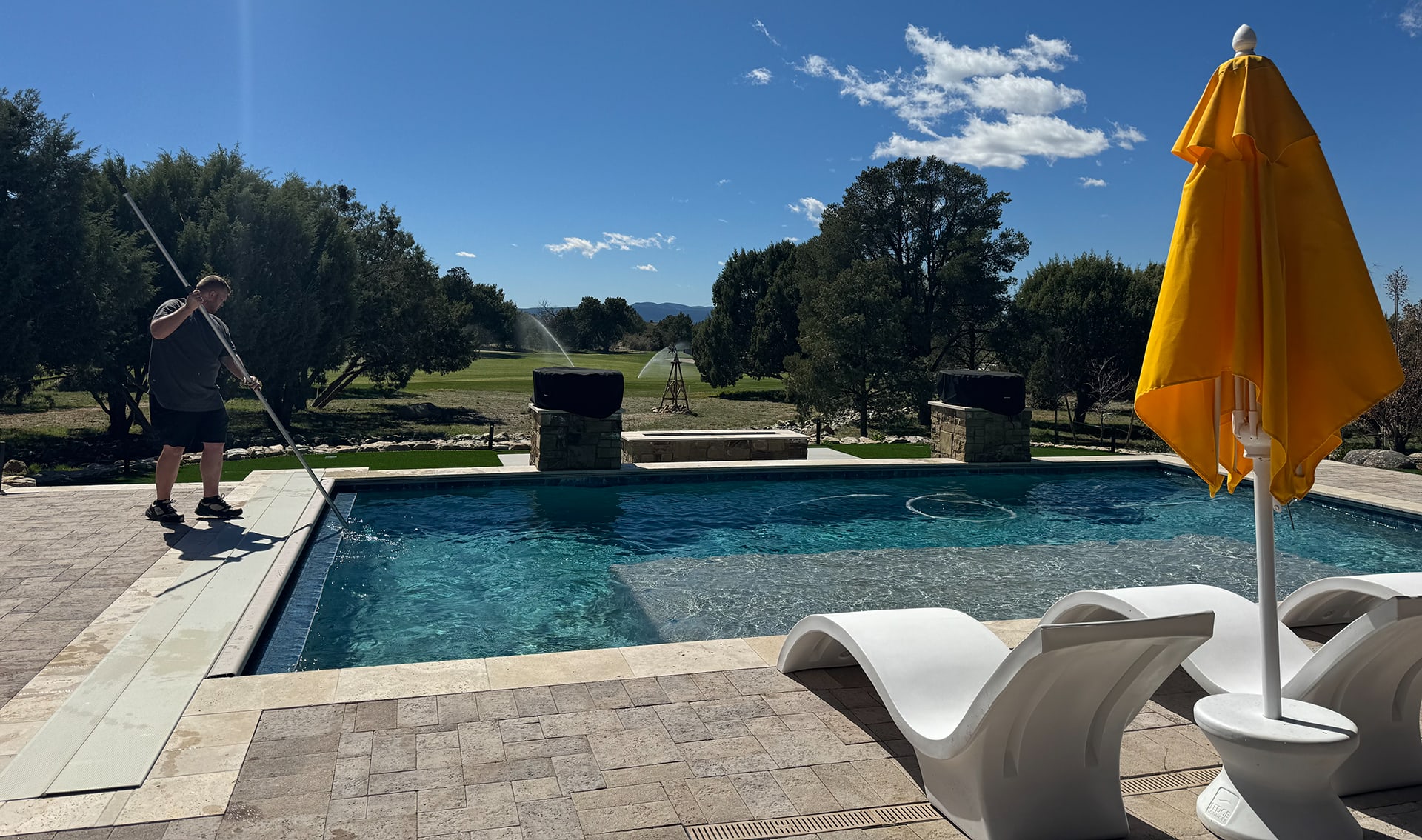 Employee cleaning client's pool in Prescott, AZ