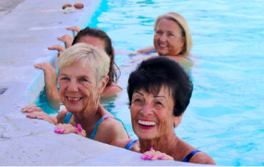 Four smiling elderly women enjoying the Healing Waters resort pool in Pagosa Springs Colorado.