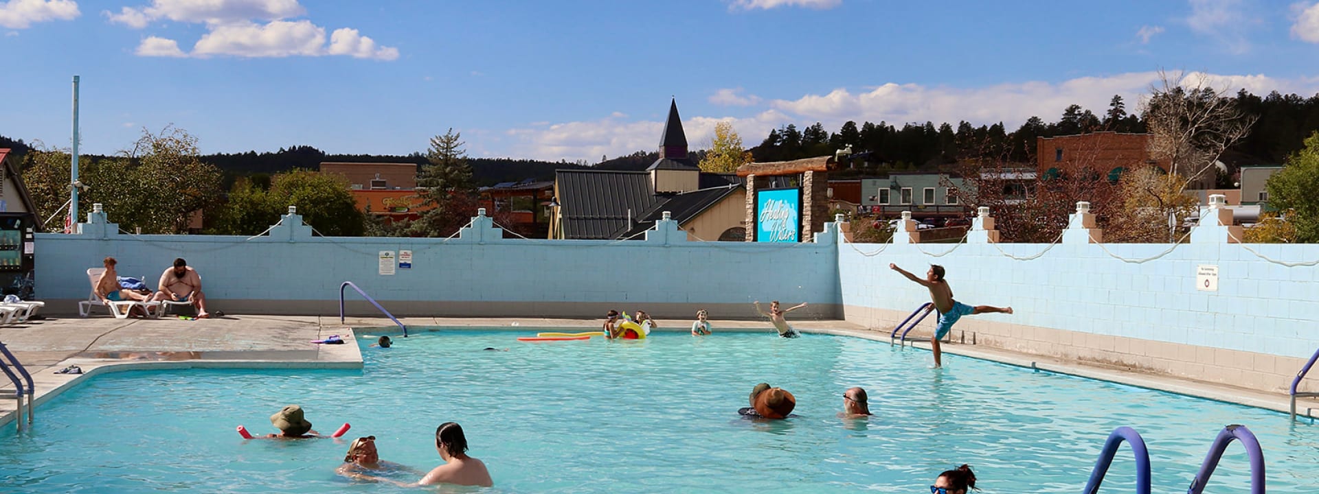 People of various ages enjoying the main hot spring pool at Healing waters in Pagosa Springs Colorado.