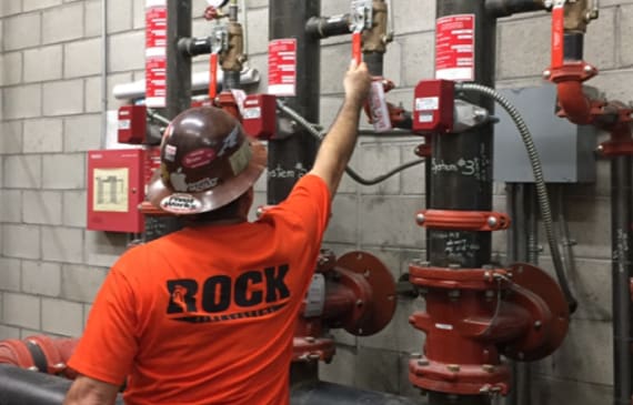 A Rock Fire employee adjusting a fire system