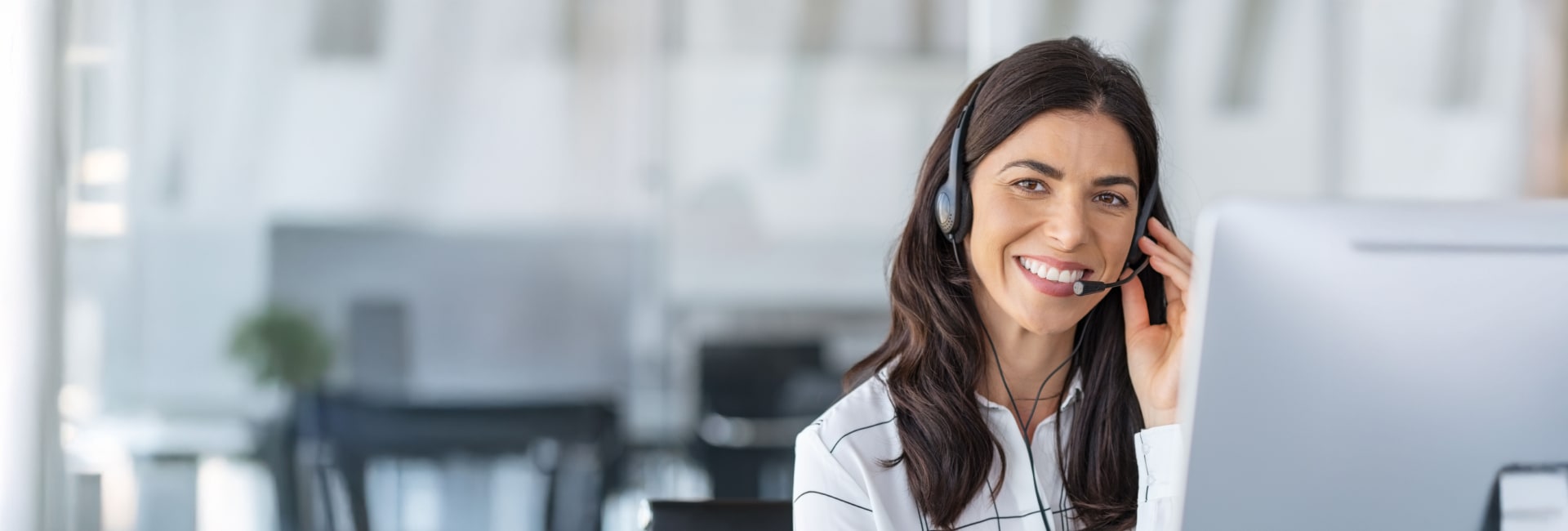 Professional operator wearing a headset and smiling, offering live bilingual call support in Corpus Christi, TX.