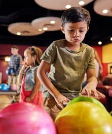 A young boy selecting a ball at the Cocopah Wild River bowling lanes